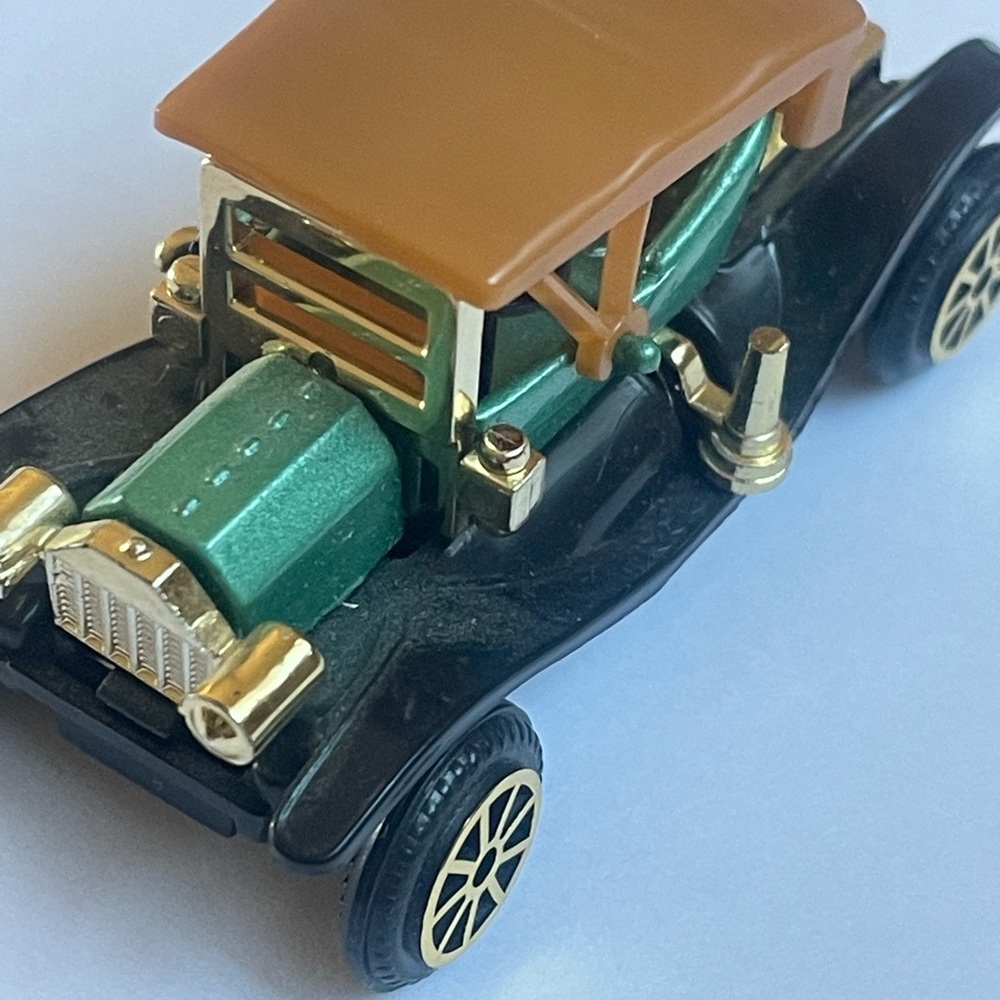 This antique old classic toy car is a four seater. It has four spoke tires. Nice